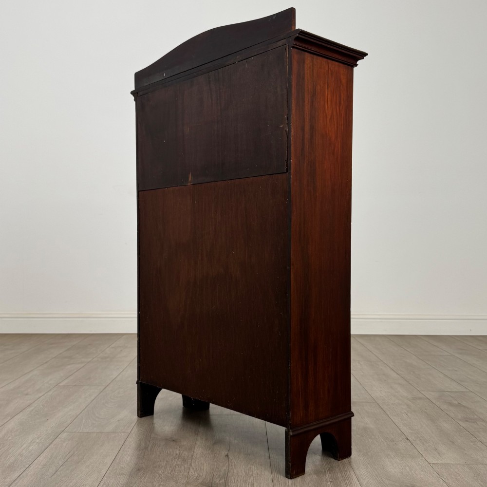 An Edwardian dark mahogany cabinet with an open upper shelf, two lower inlaid cupboard doors, and shaped bracket feet. View VIII