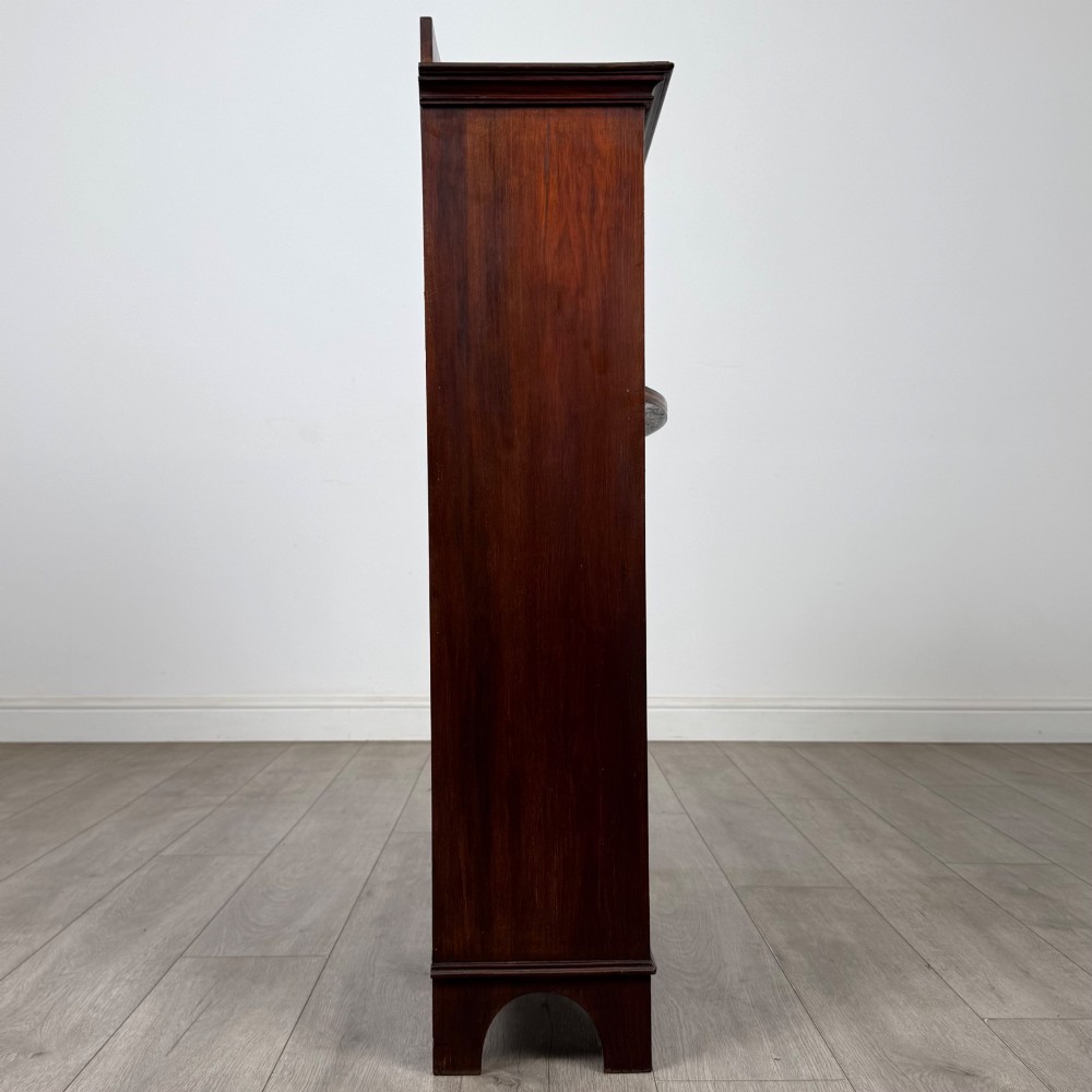 An Edwardian dark mahogany cabinet with an open upper shelf, two lower inlaid cupboard doors, and shaped bracket feet. View IX