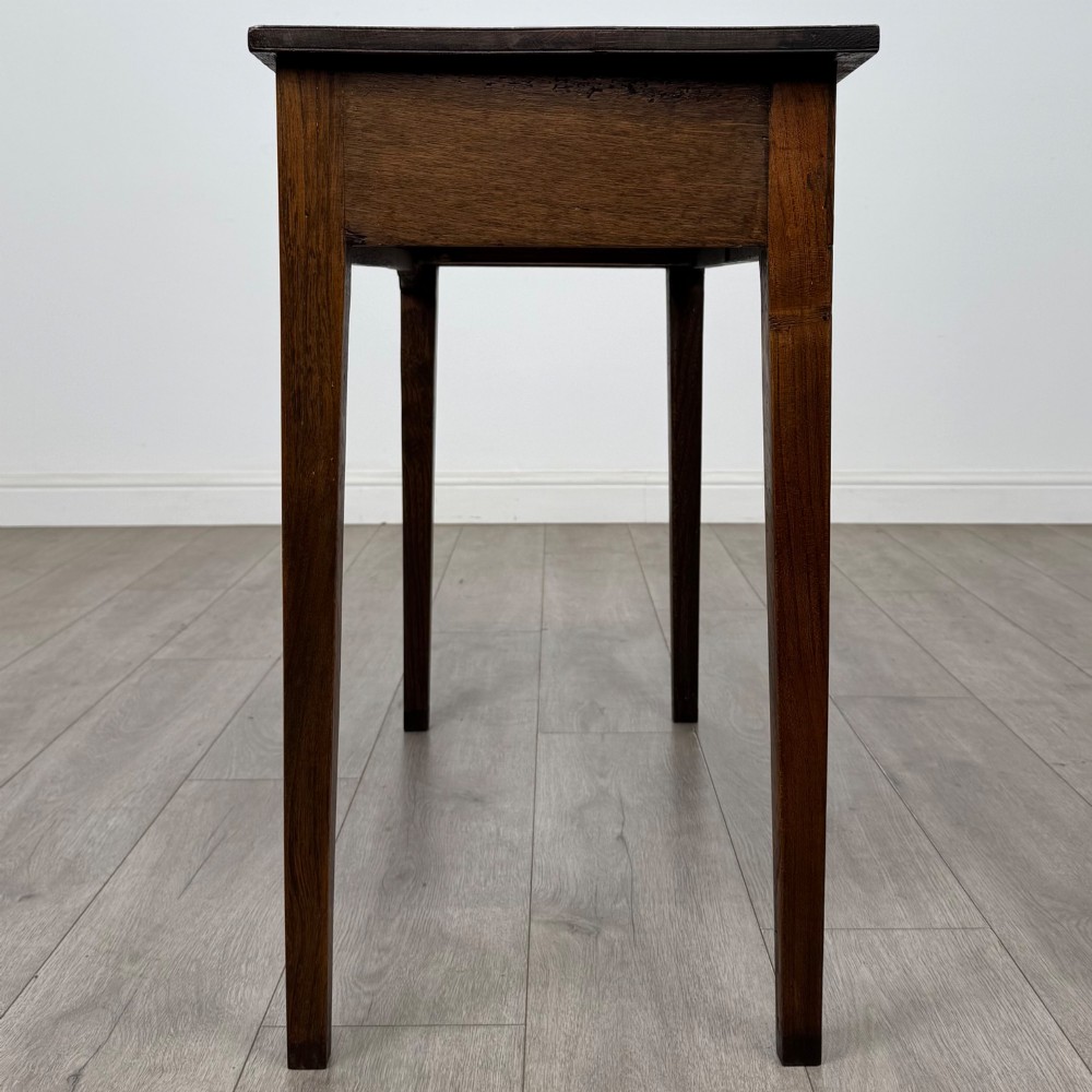 An 18th-century Georgian oak writing table with a full-width frieze drawer, two brass handles, and four square tapered legs. View III