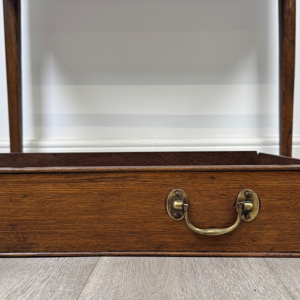 An 18th-century Georgian oak writing table with a full-width frieze drawer, two brass handles, and four square tapered legs. View XI