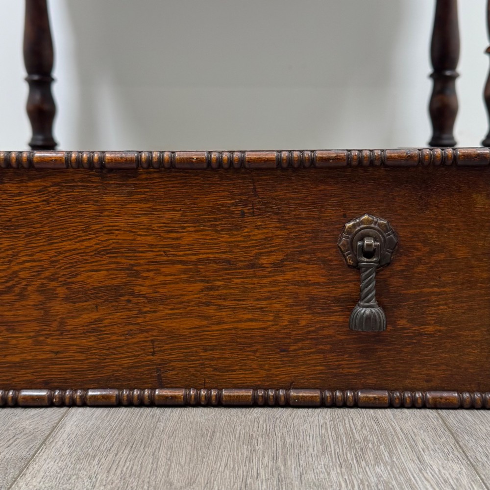 A dark oak Jacobean style bureau featuring a slanted drop-front lid, geometric moulding, a single drawer with teardrop handles, and turned legs with low stretchers. View XIII