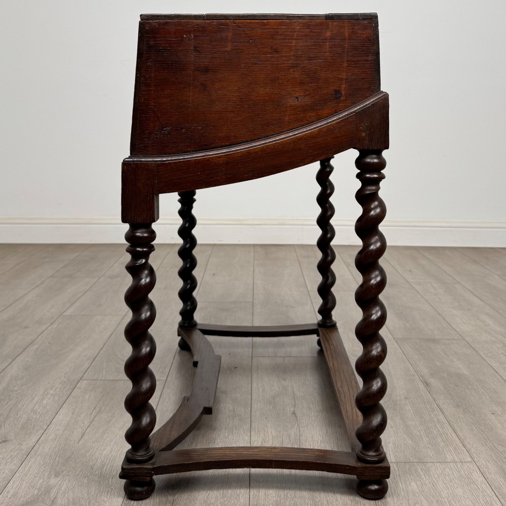 A 19th-century dark oak box on a wooden stand featuring four spiral barley twist legs and a central brass keyhole escutcheon. View III