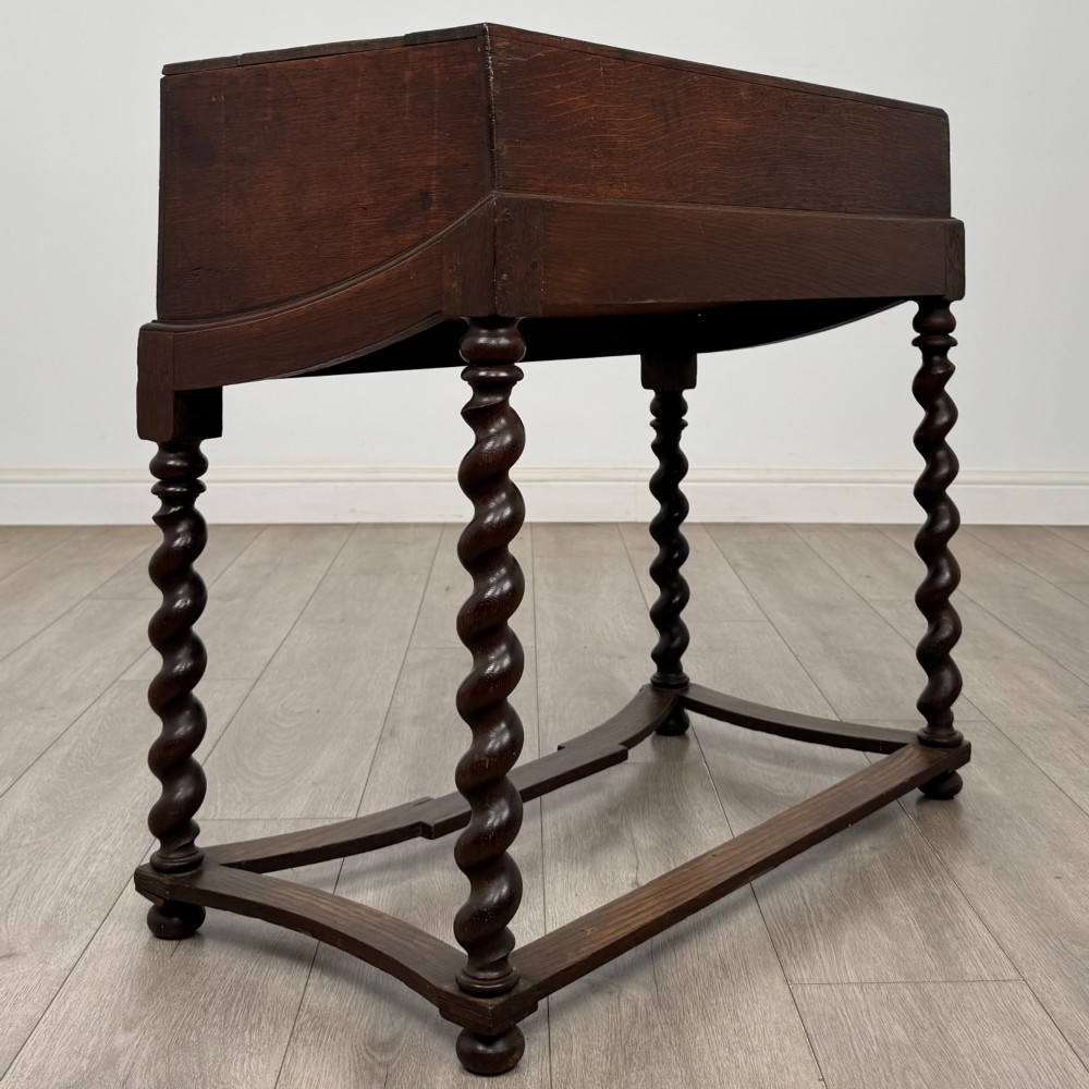 A 19th-century dark oak box on a wooden stand featuring four spiral barley twist legs and a central brass keyhole escutcheon. View IV