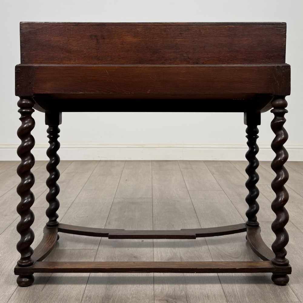 A 19th-century dark oak box on a wooden stand featuring four spiral barley twist legs and a central brass keyhole escutcheon. View V