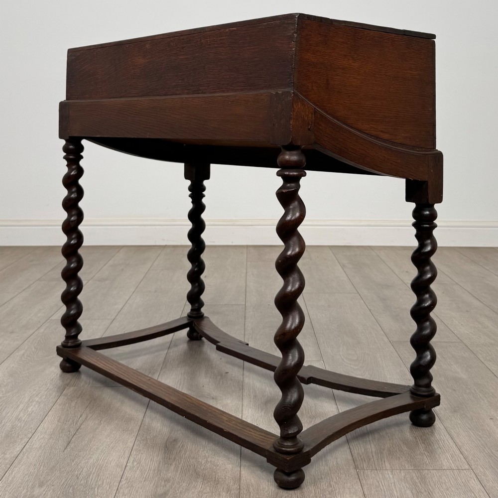 A 19th-century dark oak box on a wooden stand featuring four spiral barley twist legs and a central brass keyhole escutcheon. View VI