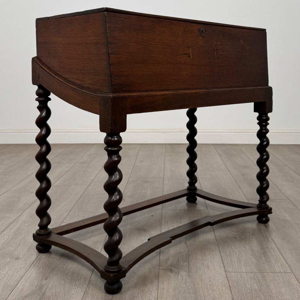 A 19th-century dark oak box on a wooden stand featuring four spiral barley twist legs and a central brass keyhole escutcheon. View VIII
