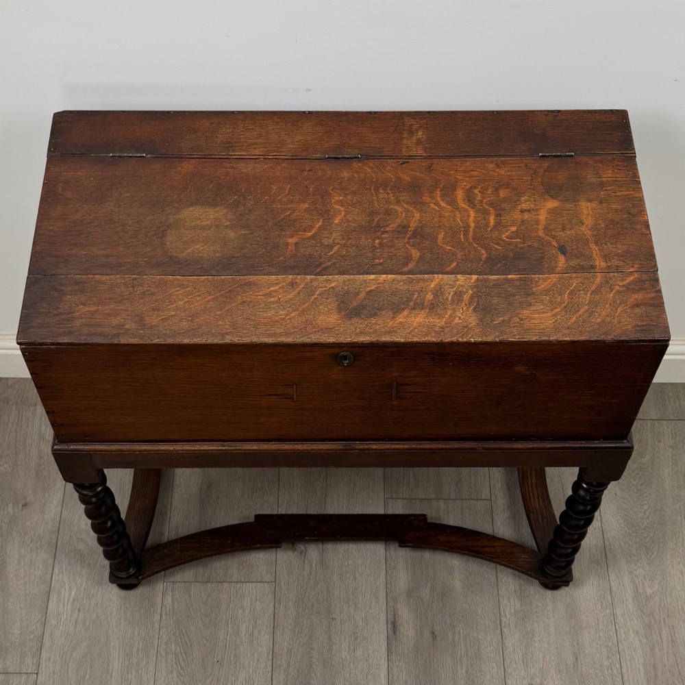 A 19th-century dark oak box on a wooden stand featuring four spiral barley twist legs and a central brass keyhole escutcheon. View IX