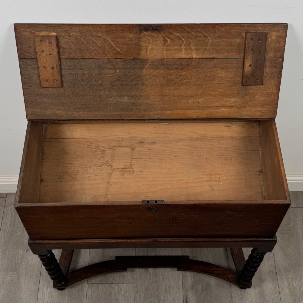 A 19th-century dark oak box on a wooden stand featuring four spiral barley twist legs and a central brass keyhole escutcheon. View X