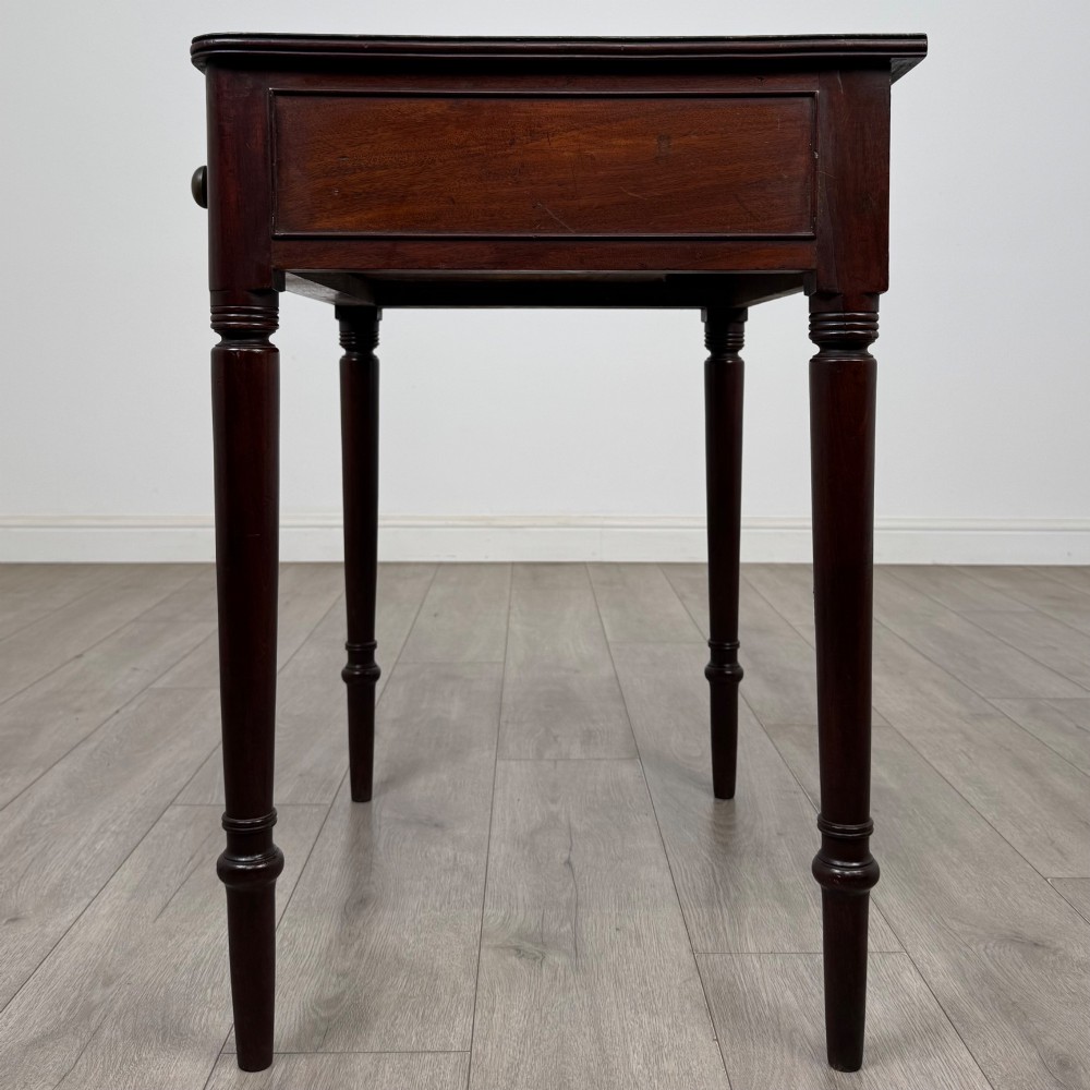 An antique dark mahogany Georgian side table featuring a single drawer with two brass sunburst knobs and slender turned legs. View III