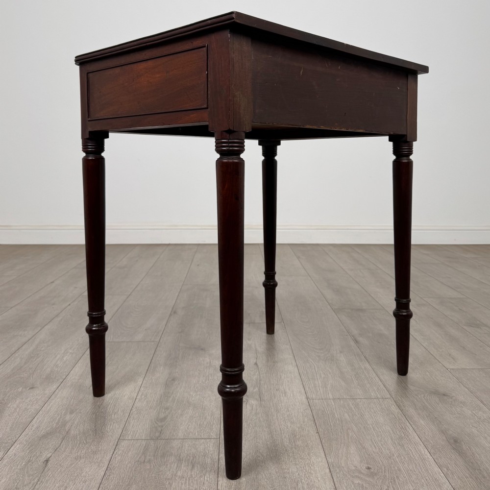 An antique dark mahogany Georgian side table featuring a single drawer with two brass sunburst knobs and slender turned legs. View IV