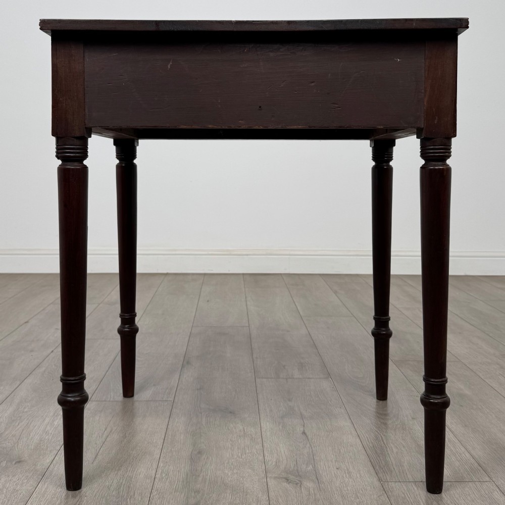 An antique dark mahogany Georgian side table featuring a single drawer with two brass sunburst knobs and slender turned legs. View V