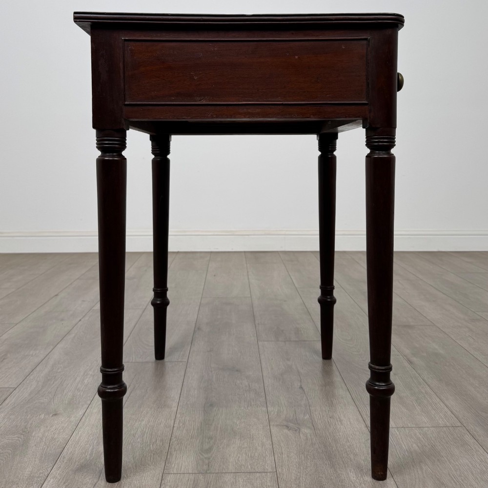 An antique dark mahogany Georgian side table featuring a single drawer with two brass sunburst knobs and slender turned legs. View VII