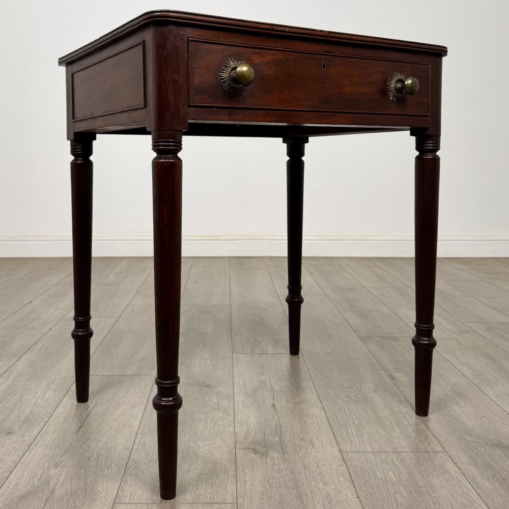An antique dark mahogany Georgian side table featuring a single drawer with two brass sunburst knobs and slender turned legs. View VIII