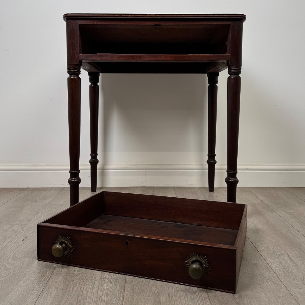 An antique dark mahogany Georgian side table featuring a single drawer with two brass sunburst knobs and slender turned legs. View X