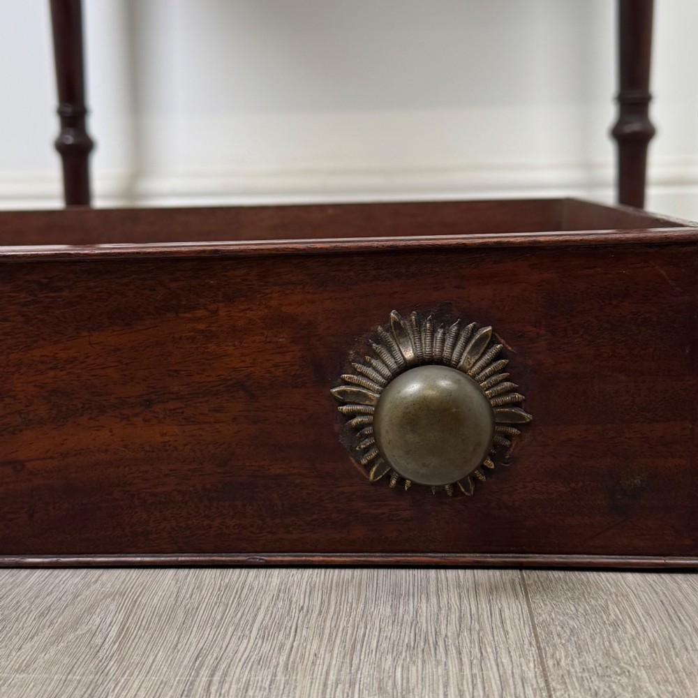 An antique dark mahogany Georgian side table featuring a single drawer with two brass sunburst knobs and slender turned legs. View XI