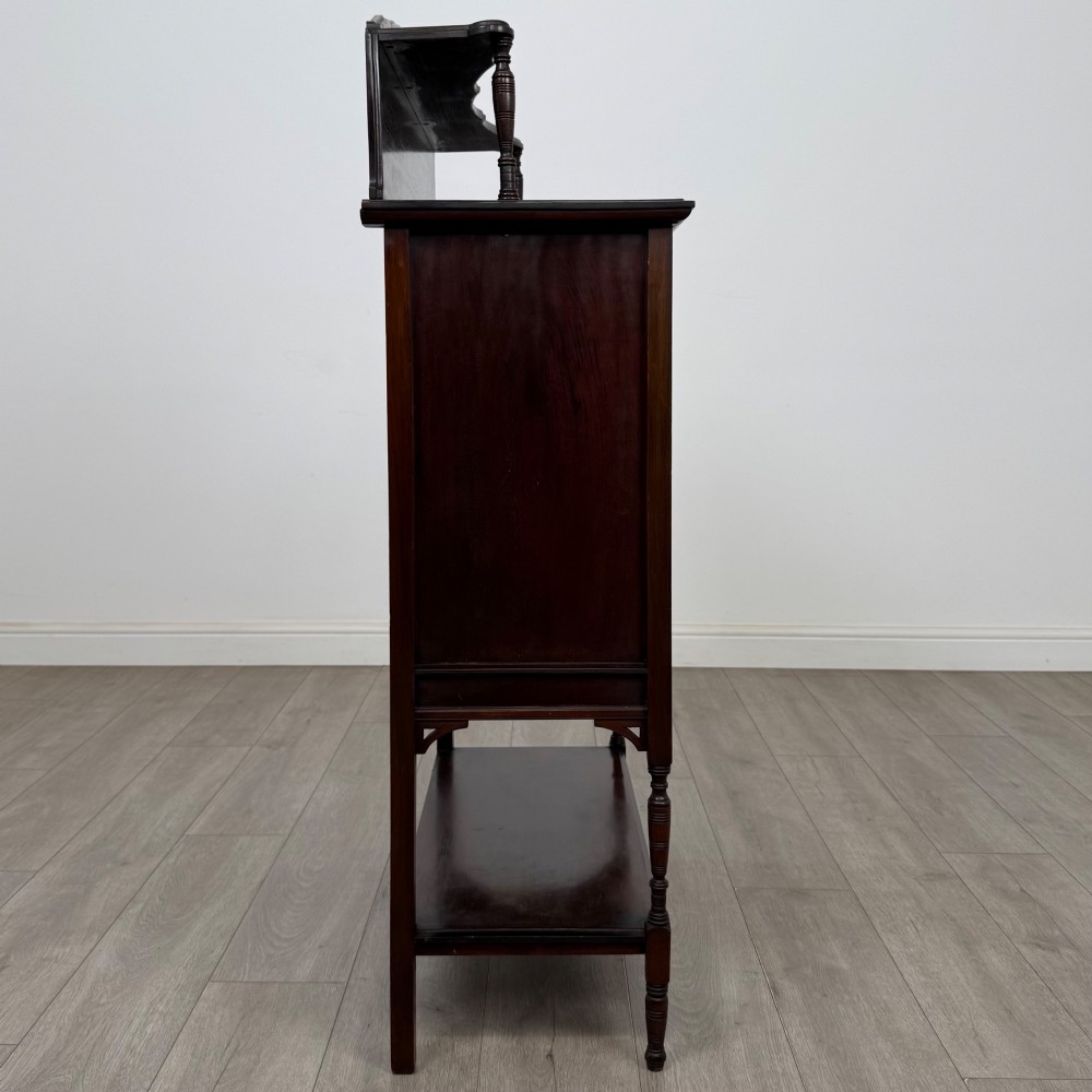 An Edwardian mahogany display cabinet featuring twin diamond-glazed doors, an upper shelf gallery, decorative fretwork, turned support legs, and an undertier. View VIII