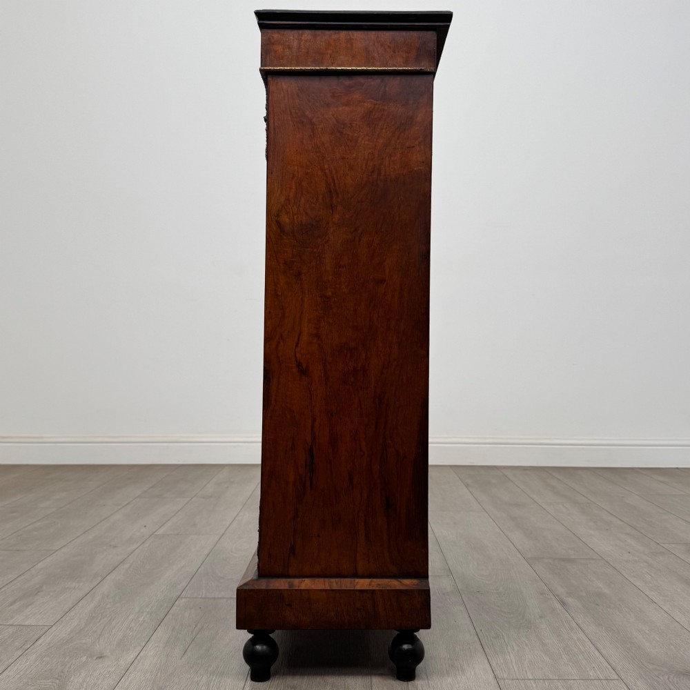 A 19th-century Victorian walnut pier cabinet featuring floral marquetry inlays, gilded metal mounts, and a single glazed door revealing interior shelves. View IV