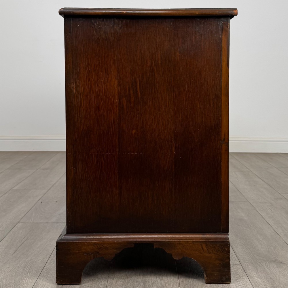 A dark oak sideboard featuring two carved upper drawers above panelled cupboard doors with decorative iron hinges and wooden knobs. View IV