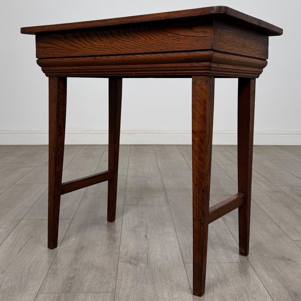 An Edwardian oak side table featuring a rectangular top, moulded frieze, tapered square legs, and low side stretchers. View II