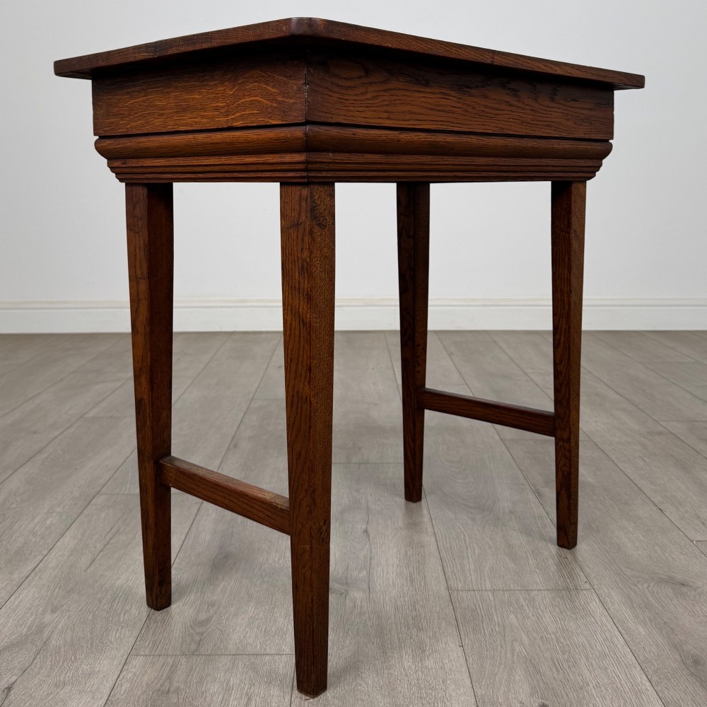 An Edwardian oak side table featuring a rectangular top, moulded frieze, tapered square legs, and low side stretchers. View IV
