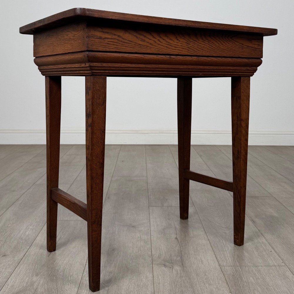 An Edwardian oak side table featuring a rectangular top, moulded frieze, tapered square legs, and low side stretchers. View VIII
