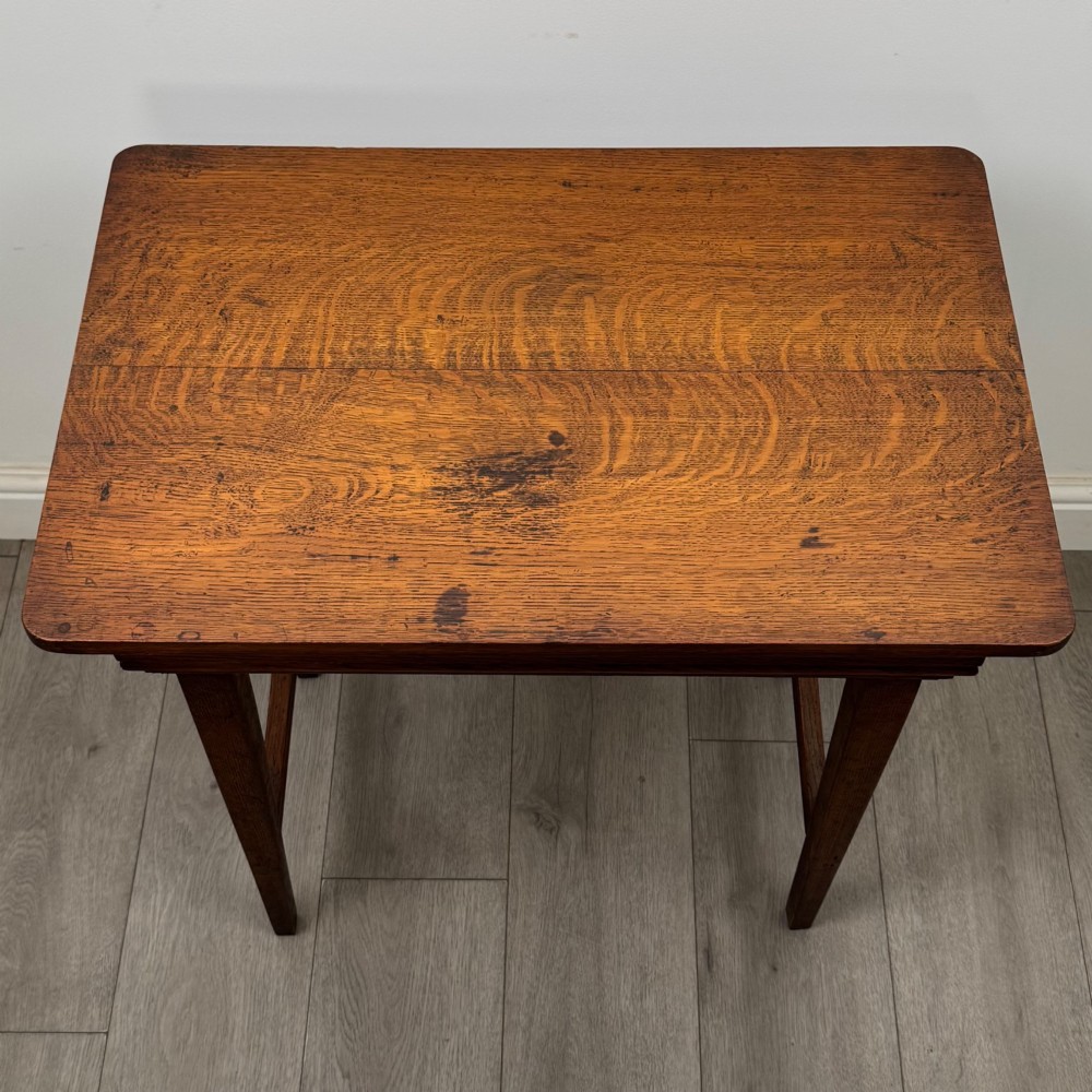 An Edwardian oak side table featuring a rectangular top, moulded frieze, tapered square legs, and low side stretchers. View IX