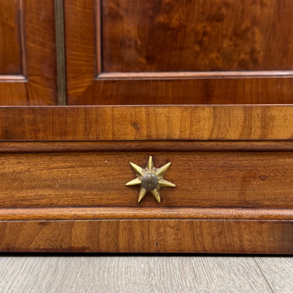 An antique Regency mahogany chiffonier featuring an upper two-tier shelf structure, a long drawer with star-shaped brass pulls, and a lower panelled double cupboard on a plinth base. View XII