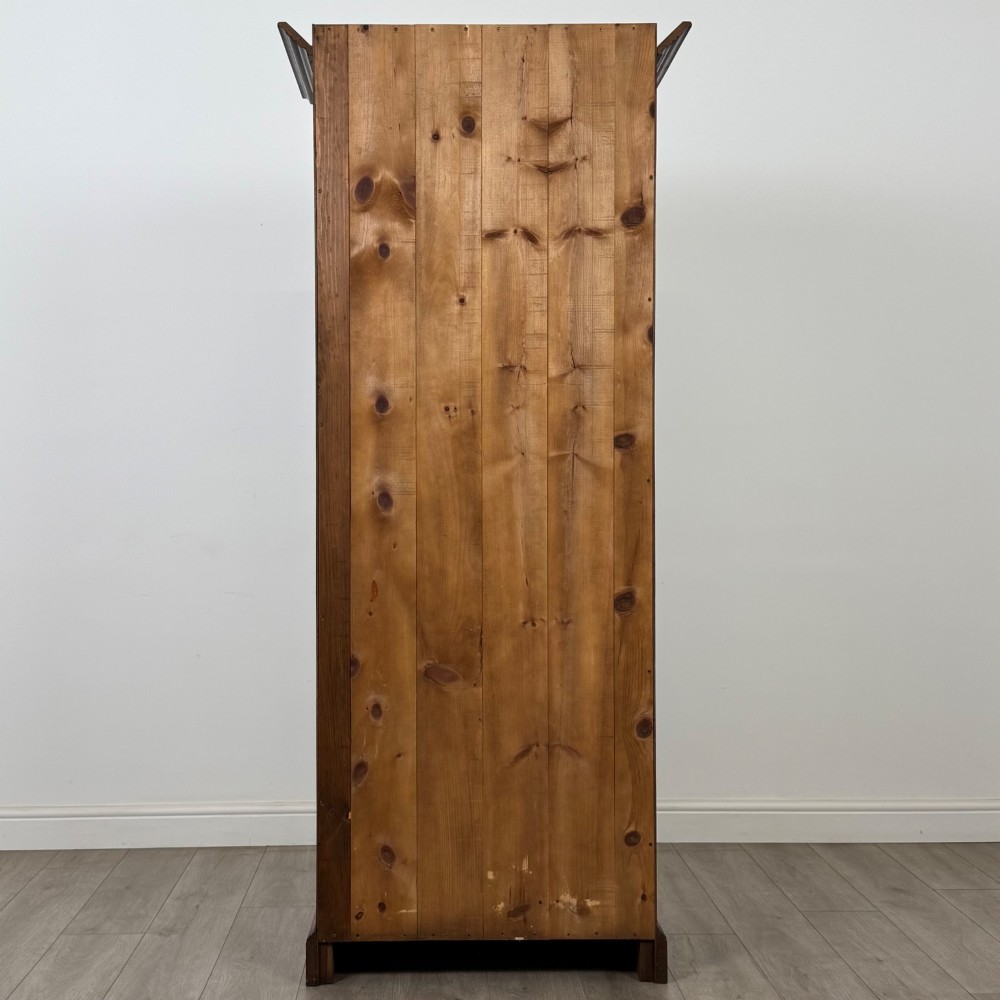 A tall 20th-century warm brown oak display cabinet featuring a single glass door with diamond-pattern astragal glazing bars, a moulded top cornice, and a solid plinth base. View VII