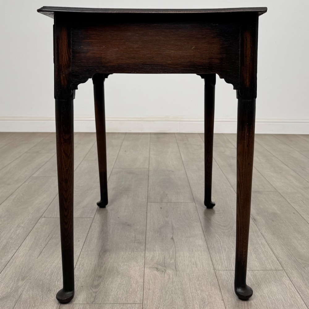 A dark oak Edwardian side table featuring two drawers with brass handles and tapered legs ending in pad feet. View III