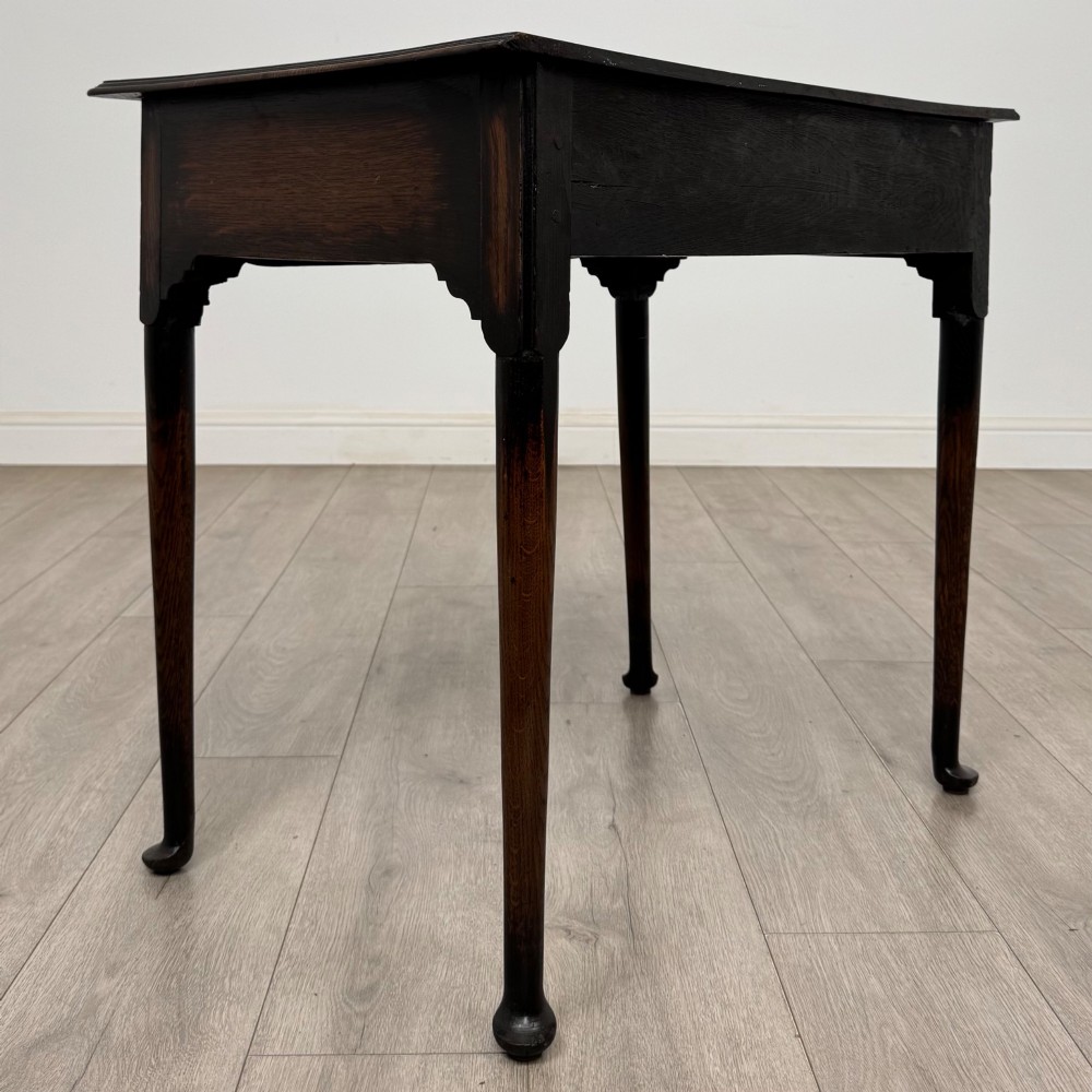 A dark oak Edwardian side table featuring two drawers with brass handles and tapered legs ending in pad feet. View IV