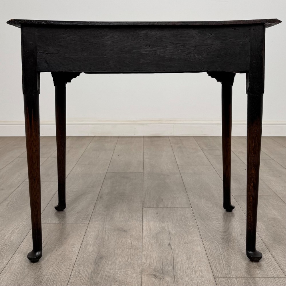 A dark oak Edwardian side table featuring two drawers with brass handles and tapered legs ending in pad feet. View V