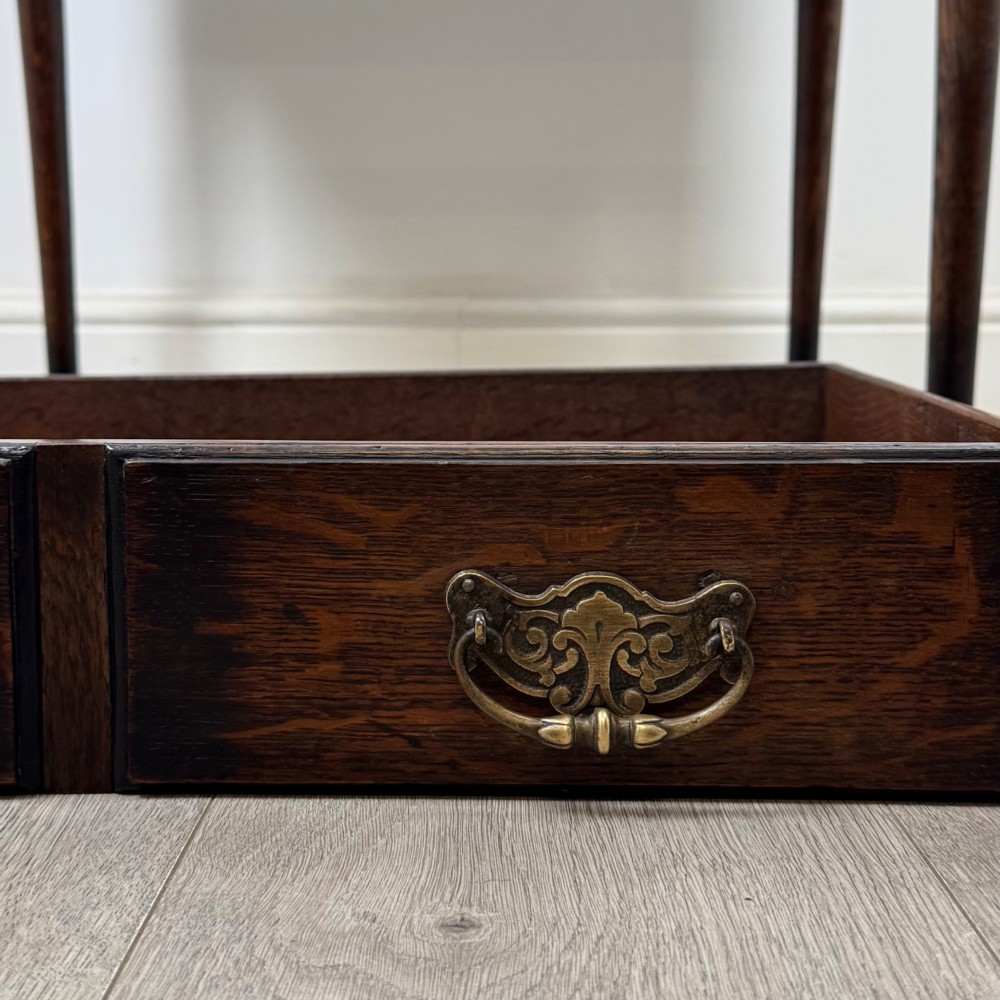 A dark oak Edwardian side table featuring two drawers with brass handles and tapered legs ending in pad feet. View XI