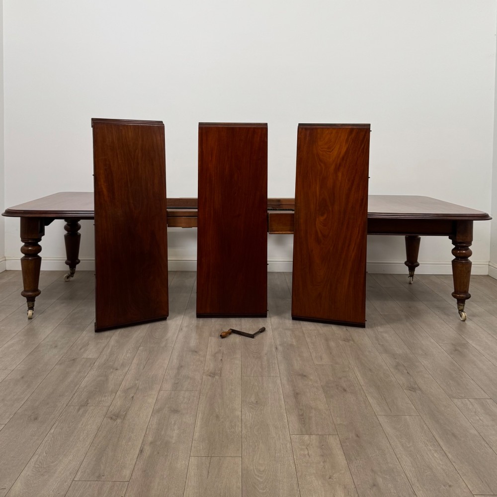 A large 19th-century Victorian mahogany extending dining table with rounded corners, turned legs, and brass castors. View II