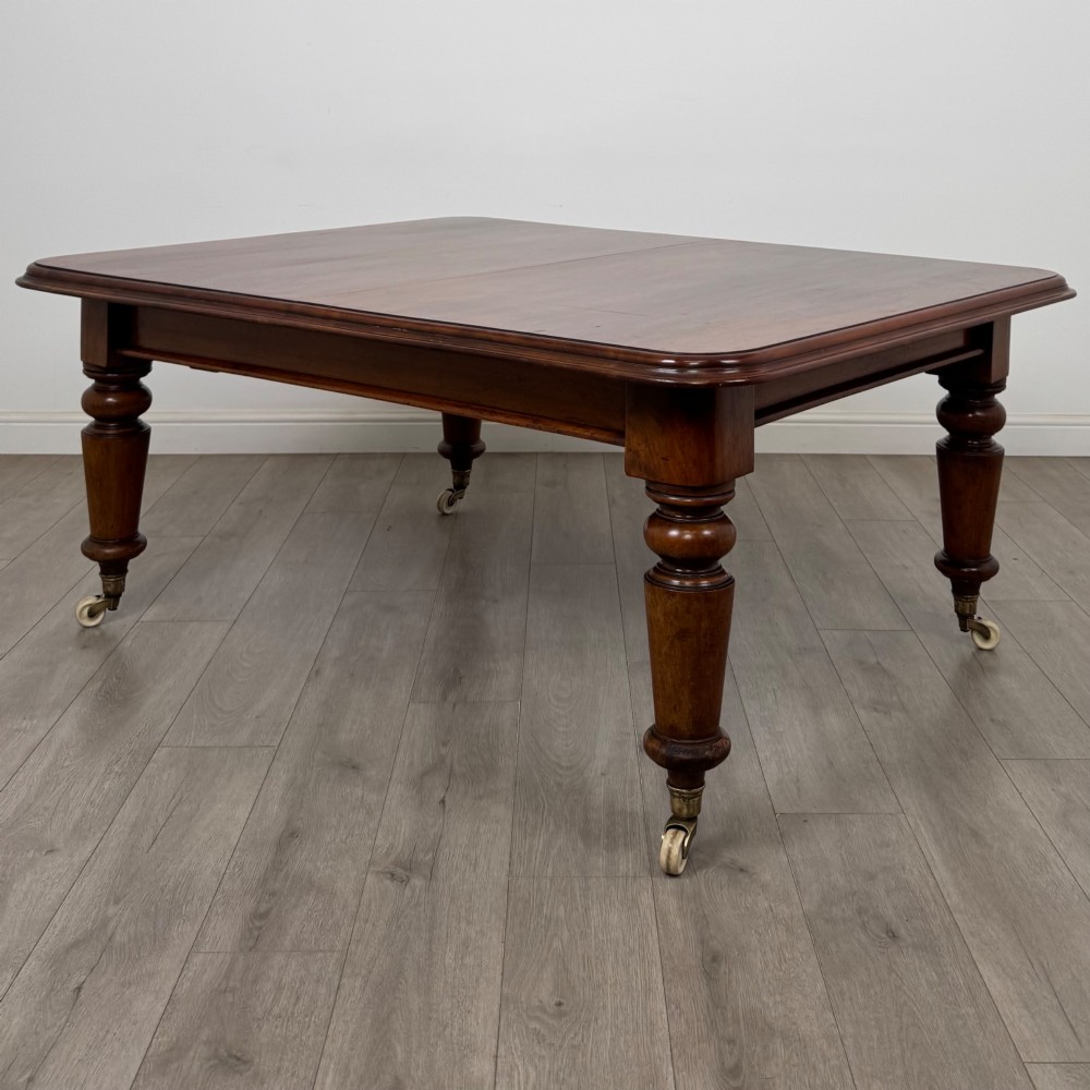 A large 19th-century Victorian mahogany extending dining table with rounded corners, turned legs, and brass castors. View III