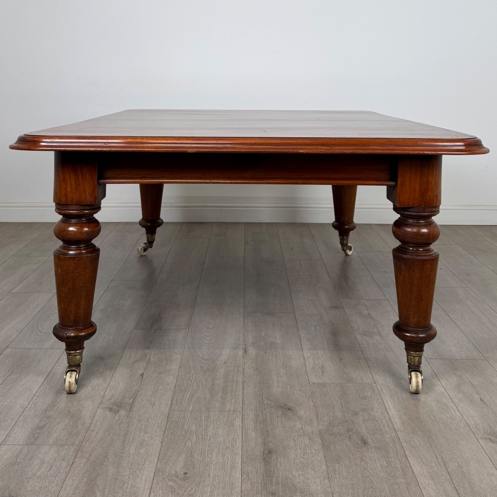 A large 19th-century Victorian mahogany extending dining table with rounded corners, turned legs, and brass castors. View V