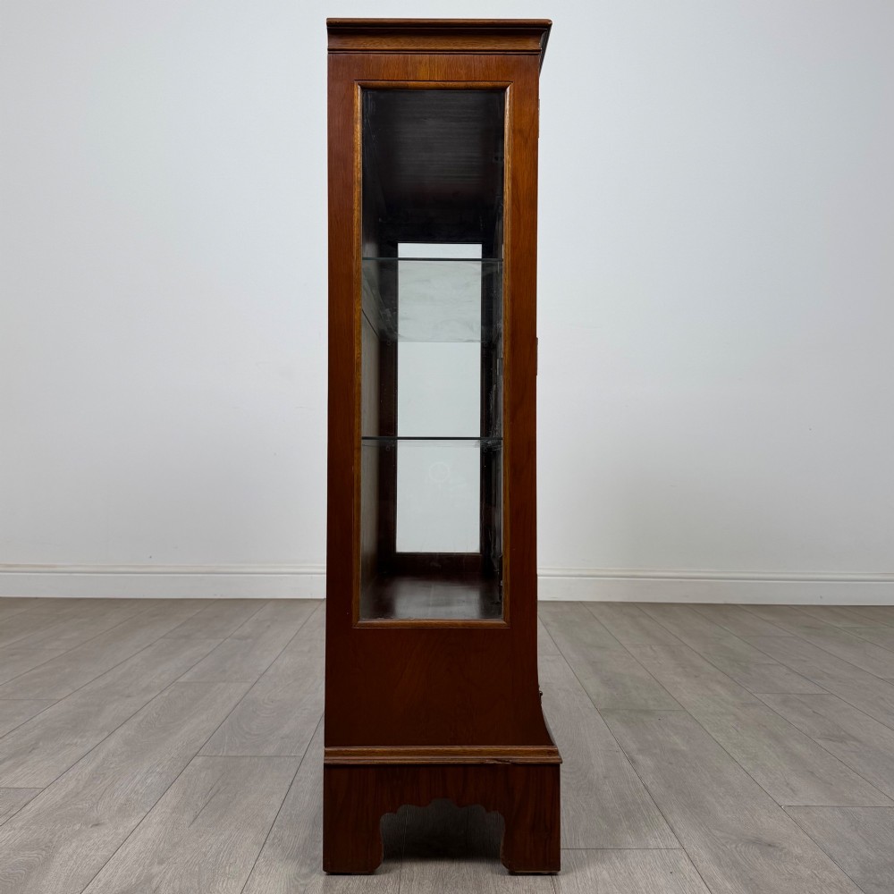 A 20th-century burr walnut display cabinet featuring two glazed doors with arched detail above two drawers on bracket feet. View VIII