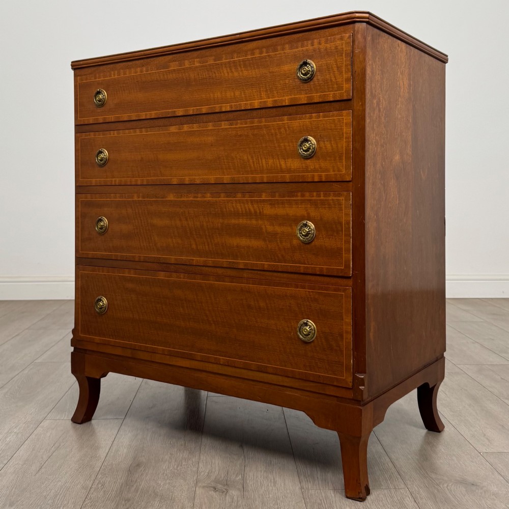 A mahogany chest of four drawers featuring decorative inlaid borders, circular brass drop handles, and bracket feet. View II