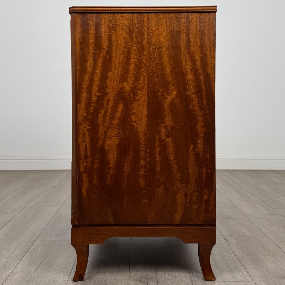 A mahogany chest of four drawers featuring decorative inlaid borders, circular brass drop handles, and bracket feet. View III
