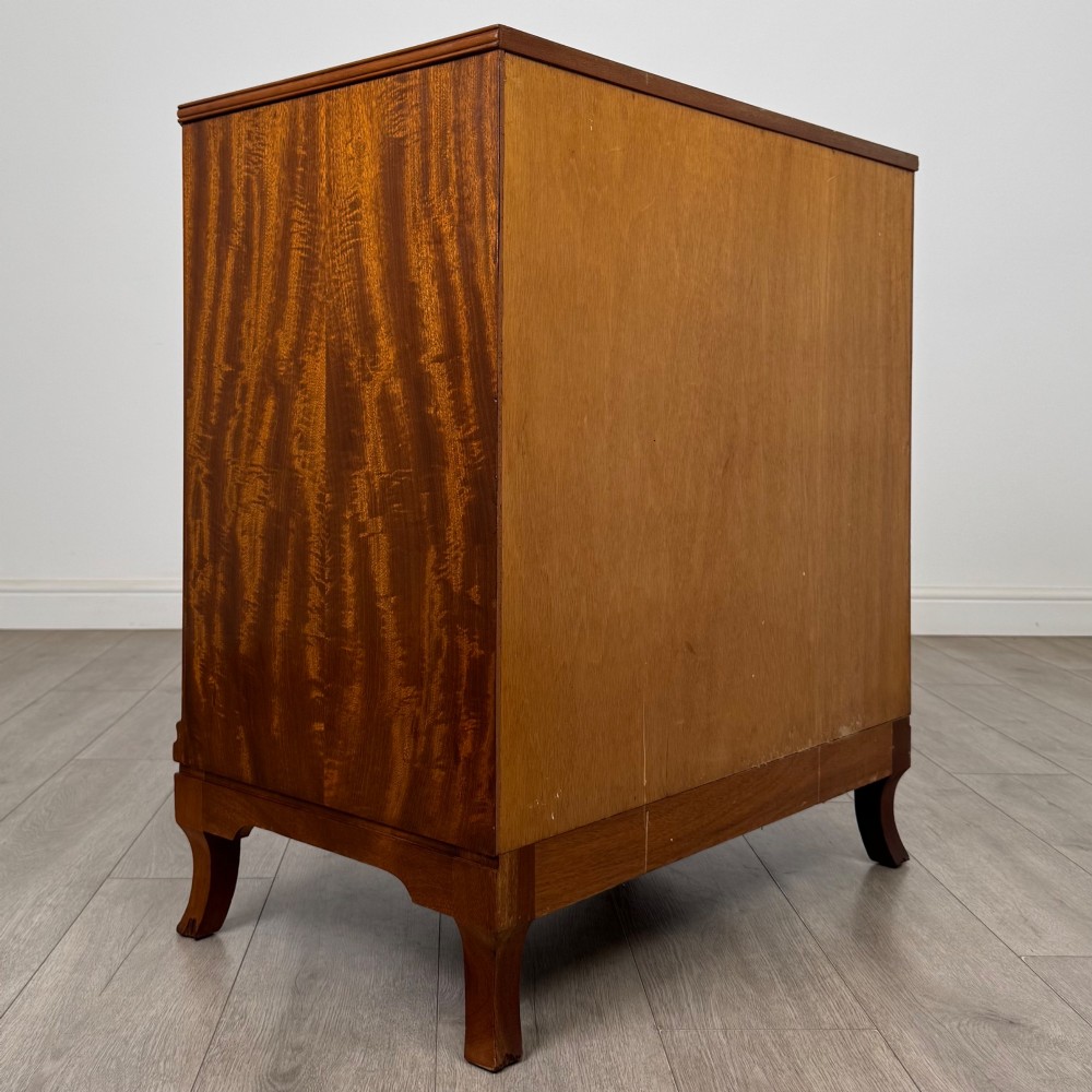 A mahogany chest of four drawers featuring decorative inlaid borders, circular brass drop handles, and bracket feet. View IV
