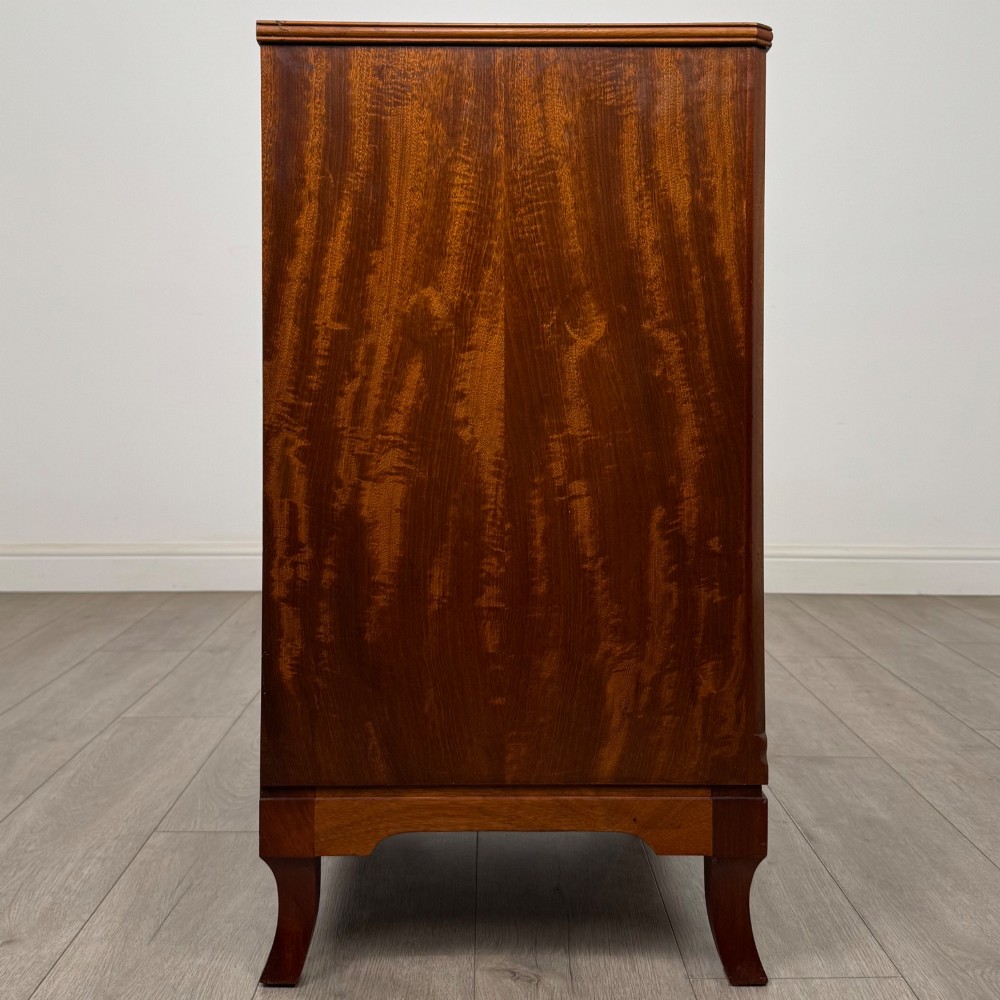 A mahogany chest of four drawers featuring decorative inlaid borders, circular brass drop handles, and bracket feet. View VII