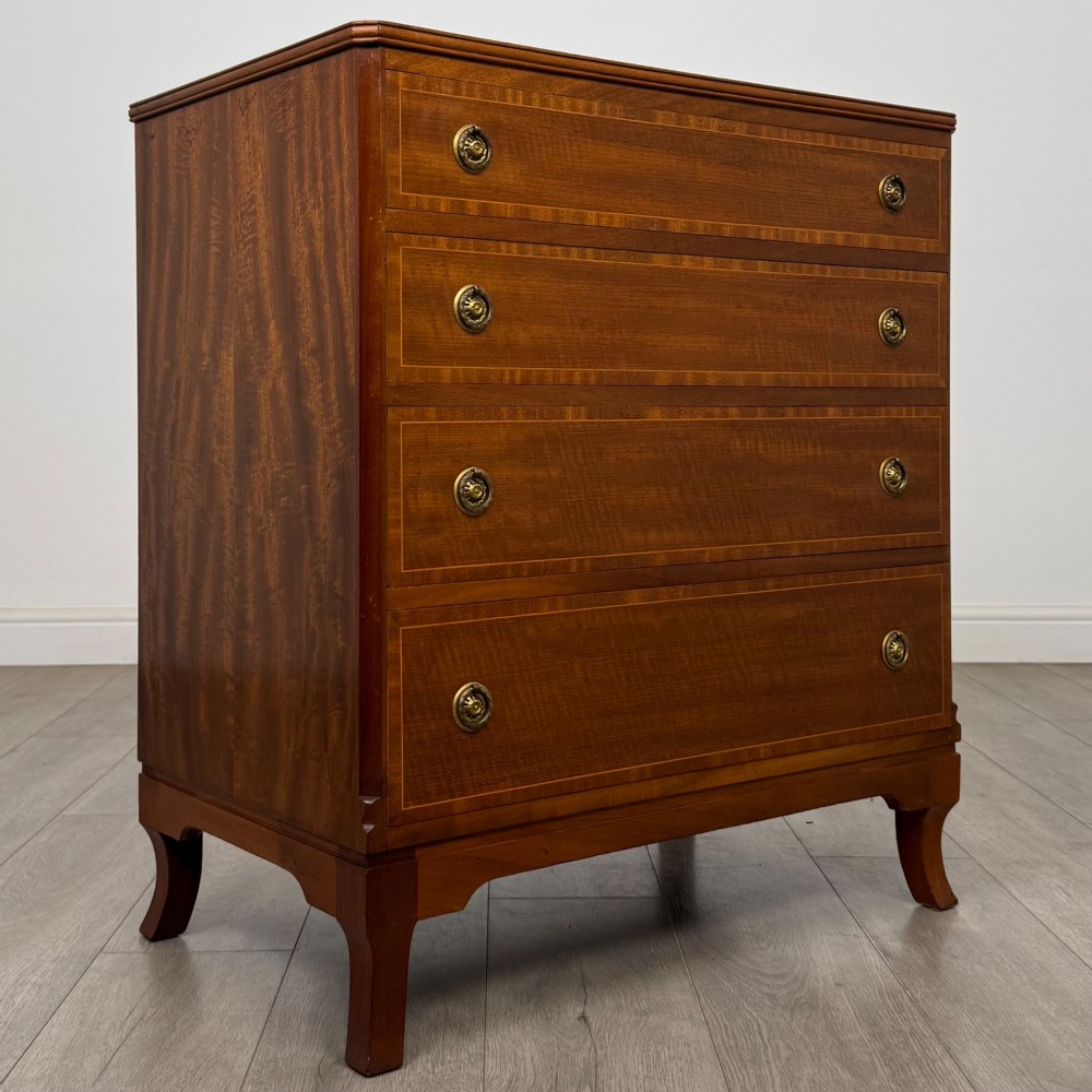 A mahogany chest of four drawers featuring decorative inlaid borders, circular brass drop handles, and bracket feet. View VIII
