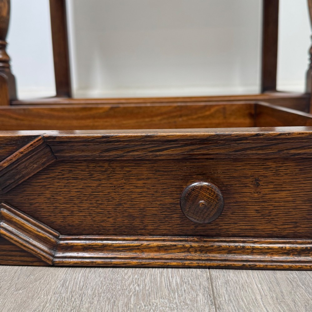 A dark oak side table featuring a single drawer with geometric mitred moulding, turned wooden knobs, a shaped lower apron, and baluster turned legs linked by low stretchers. View XI