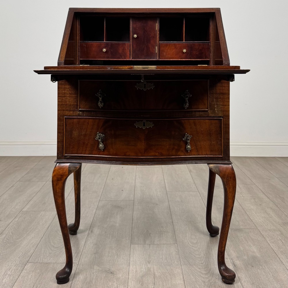 An Edwardian mahogany writing bureau featuring a sloped drop-front lid above two drawers, supported by four slender cabriole legs. View II