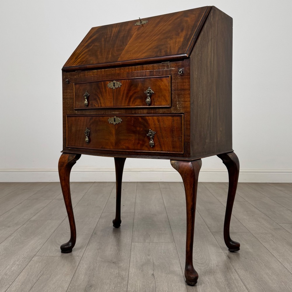 An Edwardian mahogany writing bureau featuring a sloped drop-front lid above two drawers, supported by four slender cabriole legs. View III