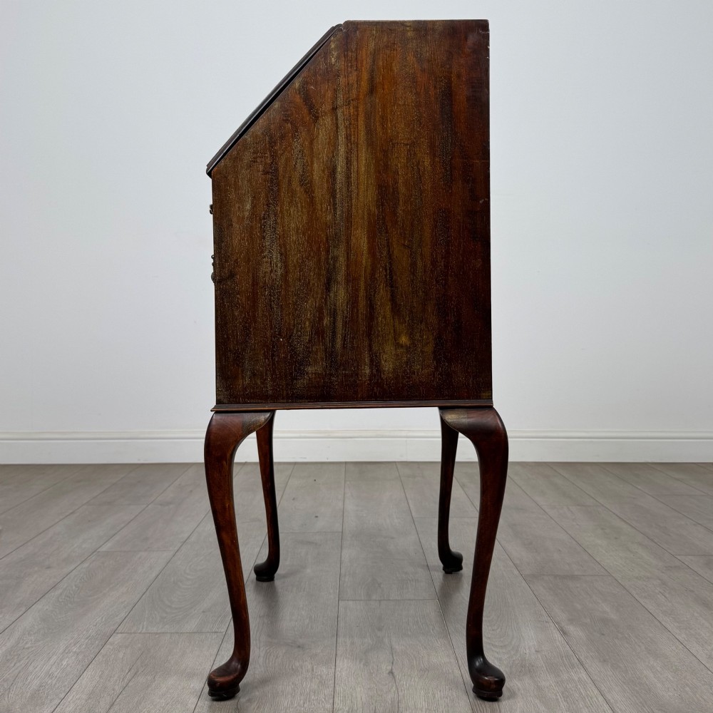 An Edwardian mahogany writing bureau featuring a sloped drop-front lid above two drawers, supported by four slender cabriole legs. View IV