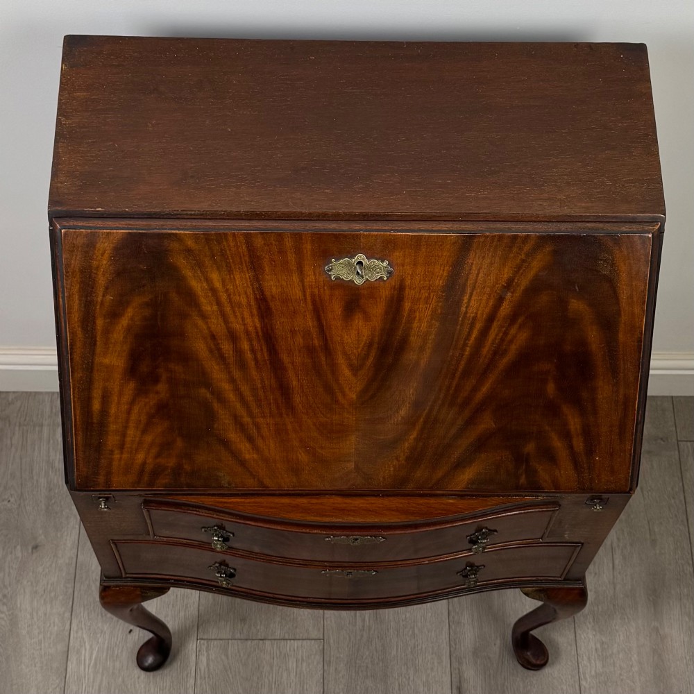 An Edwardian mahogany writing bureau featuring a sloped drop-front lid above two drawers, supported by four slender cabriole legs. View X