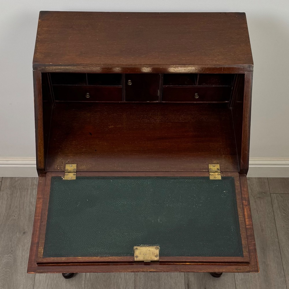 An Edwardian mahogany writing bureau featuring a sloped drop-front lid above two drawers, supported by four slender cabriole legs. View XI