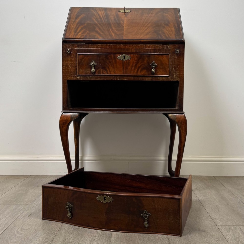 An Edwardian mahogany writing bureau featuring a sloped drop-front lid above two drawers, supported by four slender cabriole legs. View XII