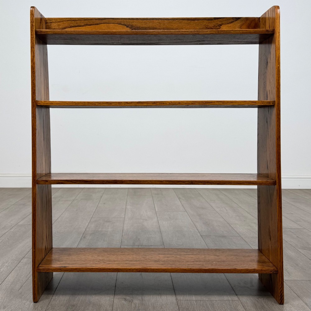 An open golden oak bookcase featuring four horizontal shelves arranged vertically with solid side panels. View II