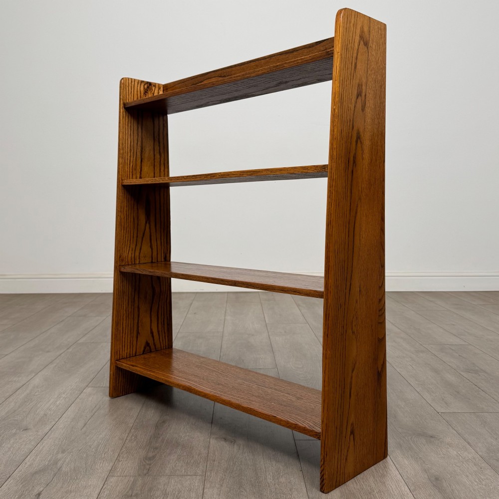 An open golden oak bookcase featuring four horizontal shelves arranged vertically with solid side panels. View III